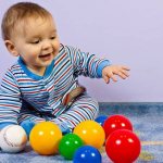 Ребенок с разноцветными мячиками
